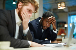 Stressed businessmen looking at laptop display