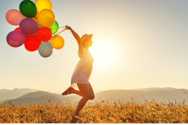 woman running happily with balloons