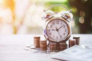 Close up of time and money with green bokeh background ,Business Finance and Money concept,Save money for prepare in the future.time is money concept